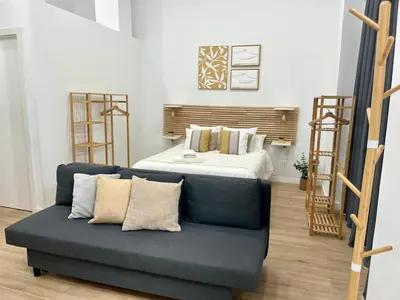 a living room with a couch and a bed at Loft cerca de playa y Ciudad de Artes y Ciencias in Valencia