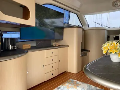 a table with a bottle of wine and flowers on a vehicle at The Valencia Yacht Experience in Valencia