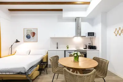 a room with a bed and a table and chairs at Moontels Plaza de Vannes in Valencia