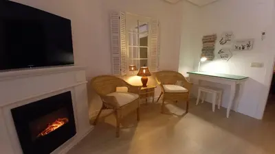 a living room with a fireplace and a flat screen tv at El rinconet in Partida de La Cañada
