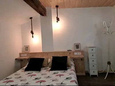 a bedroom with a bed with a wooden headboard and lights at APARTAMENTO MARÍTIMO in Valencia