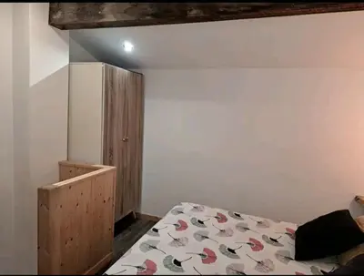 a bedroom with a bed and a wooden cabinet at APARTAMENTO MARÍTIMO in Valencia