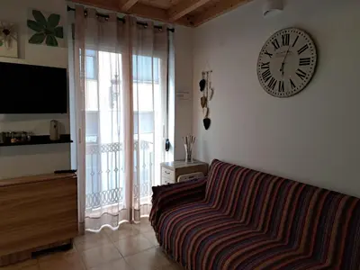 a living room with a couch and a clock on the wall at APARTAMENTO MARÍTIMO in Valencia