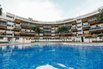 a large swimming pool in front of a building at Lujoso apartamento de dos habitaciones en la playa de Canet in Canet de Berenguer