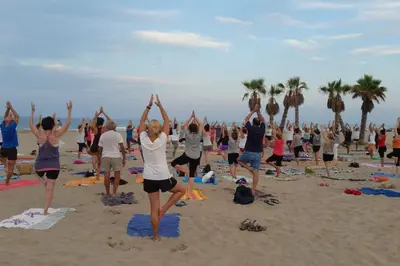 a group of people doing yoga on the beach at Lujoso apartamento de dos habitaciones en la playa de Canet in Canet de Berenguer