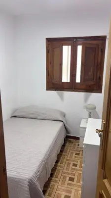 a bedroom with a bed and a dresser and windows at Primera línea de playa in Valencia