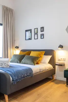 a bed with yellow pillows on it in a room at Travel Habitat Patraix Suite con Terracita in Valencia