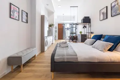 a bedroom with a large bed and a kitchen at Travel Habitat Sant Isidre Suite in Valencia