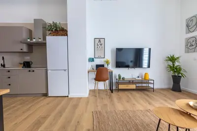a kitchen with a white refrigerator and a table at Travel Habitat Sant Isidre Suite in Valencia