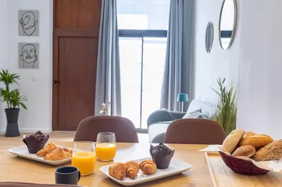 a table topped with plates of bread and orange juice at Travel Habitat Sant Isidre Suite in Valencia