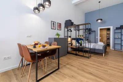 a living room with a table and chairs and a bedroom at Travel Habitat Sant Isidre Suite in Valencia