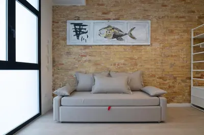 a couch in a living room with a brick wall at NEW BEACH flats VALENCIA in Valencia
