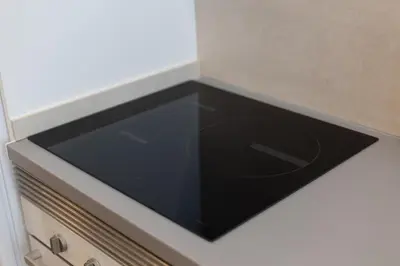 a stove top oven with a black counter top at NEW BEACH flats VALENCIA in Valencia