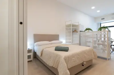 a bedroom with a bed with a green pillow on it at NEW BEACH flats VALENCIA in Valencia