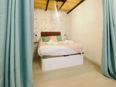 a bedroom with a bed with blue curtains at Beautiful LOFT in the HEART of Ruzafa, SOHO in Valencia