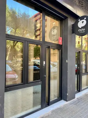 a store front with many glass windows on a street at Osito Hub - Poeta Durán in Valencia