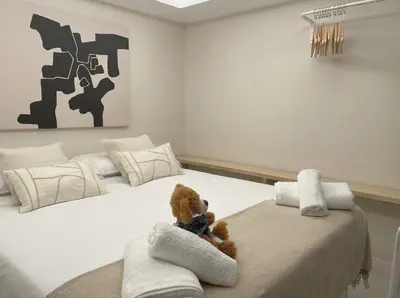 a teddy bear sitting on a bed in a bedroom at Osito Hub - Poeta Durán in Valencia