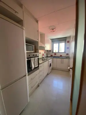 a large kitchen with white appliances and a window at Excelente apartamento en Benimaclet in Valencia