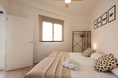 a bedroom with a large white bed with pillows at Cruz Cubierta Apartments in Valencia