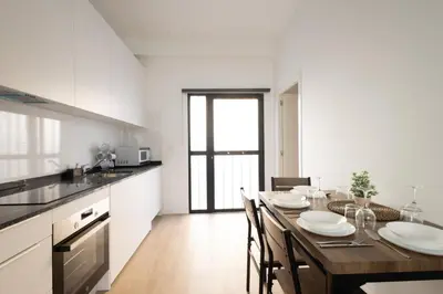 a kitchen with a wooden table with chairs and a dining room at Cruz Cubierta Apartments in Valencia