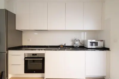 a kitchen with white cabinets and a microwave at Cruz Cubierta Apartments in Valencia