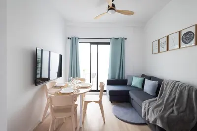 a living room with a table and a blue couch at Cruz Cubierta Apartments in Valencia