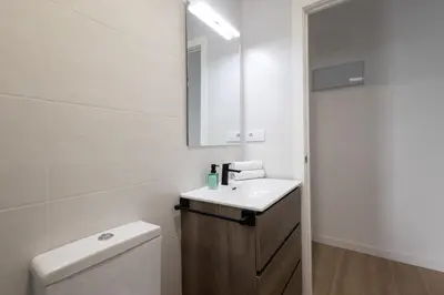 a white bathroom with a sink and a mirror at Cruz Cubierta Apartments in Valencia