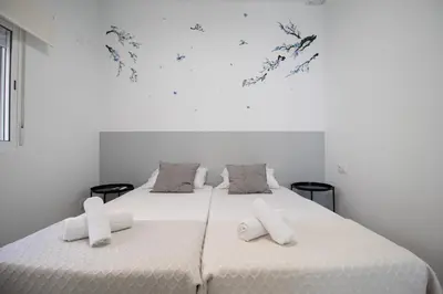 a white bedroom with a large bed with white sheets at Congresos Flat by Concept Flats in Valencia