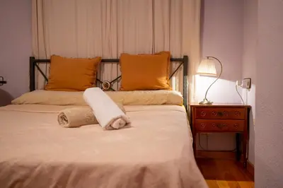 a bedroom with a bed with a towel on it at La casa de Lili acerca de palacio de música in Valencia