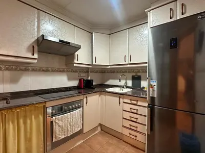 a kitchen with white cabinets and a stainless steel refrigerator at La casa de Lili acerca de palacio de música in Valencia