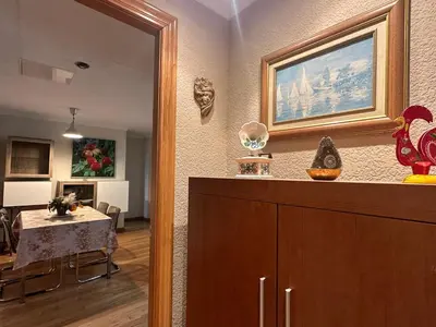 a living room with a table and a mirror at La casa de Lili acerca de palacio de música in Valencia