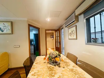 a dining room table with a vase of flowers on it at La casa de Lili acerca de palacio de música in Valencia