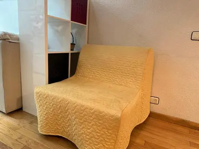 a wooden chair sitting in a room at La casa de Lili acerca de palacio de música in Valencia
