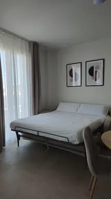 a bed in a bedroom with two pictures on the wall at Imperial Apartamentos Valencia in Valencia