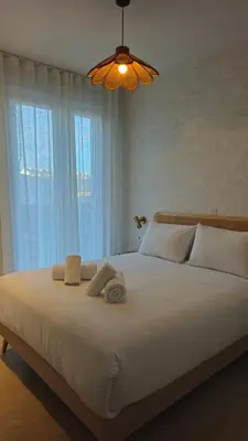 a bedroom with a large white bed with towels on it at Imperial Apartamentos Valencia in Valencia