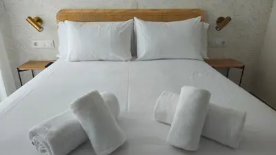 a white bed with four towels on it at Imperial Apartamentos Valencia in Valencia