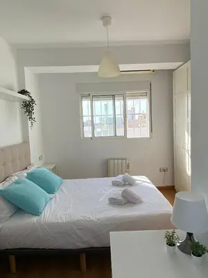 a bedroom with a large white bed with blue pillows at SingularStays Valero III in Valencia