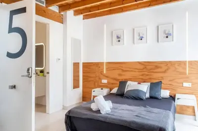 a bedroom with a bed with a wooden wall at Apartamento soleado en plaza del Carmen in Valencia