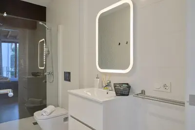 a white bathroom with a sink and a mirror at Apartamento soleado en plaza del Carmen in Valencia