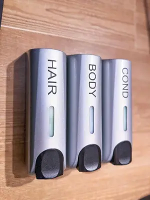 three silver batteries sitting on top of a wooden table at Studio Aiora in Valencia