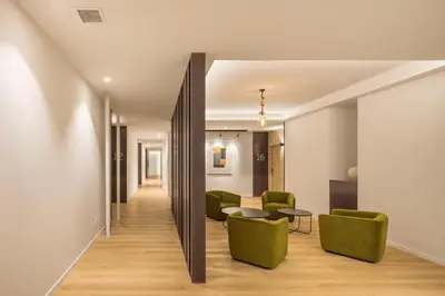 a hallway with green chairs and a table at Mon Suites Jardín de Ayora in Valencia