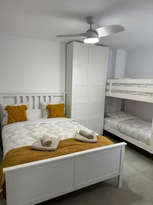 a bedroom with a white bed with two bunk beds at UIM Mediterraneo Cendoya 2 Wifi in Puerto de Sagunto