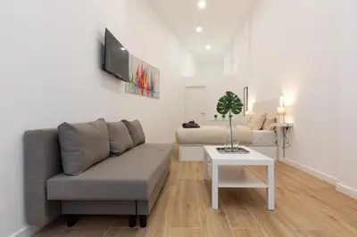 a living room with a couch and a table at Nuevo loft en playa y cerca del centro, AC y Wifi in Valencia