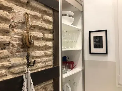 a room with a brick wall and a shelf with glasses at Loft con estilo y terraza en centro histórico in Valencia