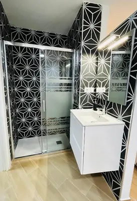 a bathroom with a black and white tiled wall at Patraix nice suite in Valencia
