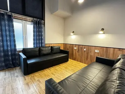 a living room with a black leather couch and a window at Lliri 7 in Valencia