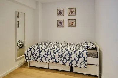 a bedroom with a bed with a black and white comforter at REINA FLAT in Valencia