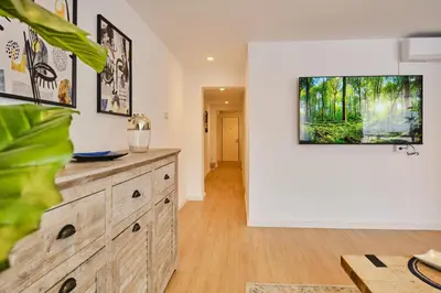 a living room with a wooden dresser with a tv on the wall at REINA FLAT in Valencia