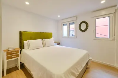 a white bedroom with a large bed and two windows at REINA FLAT in Valencia