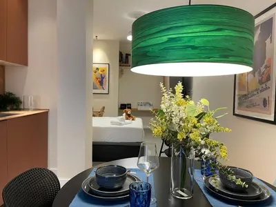 a dining room with a table with a green lamp at Osito Hub - Duque de Gaeta in Valencia